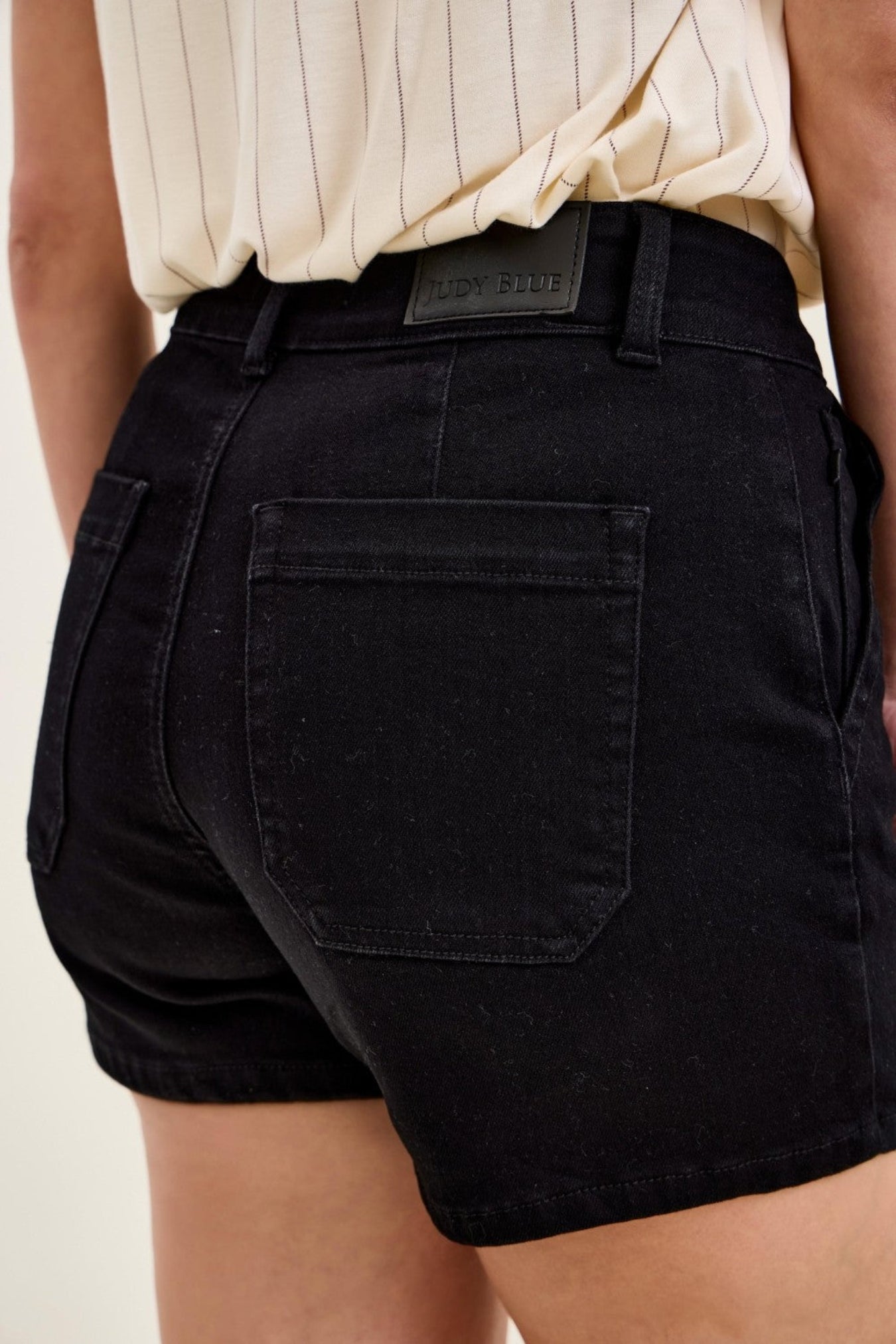 Black shorts worn by a person with a neutral background