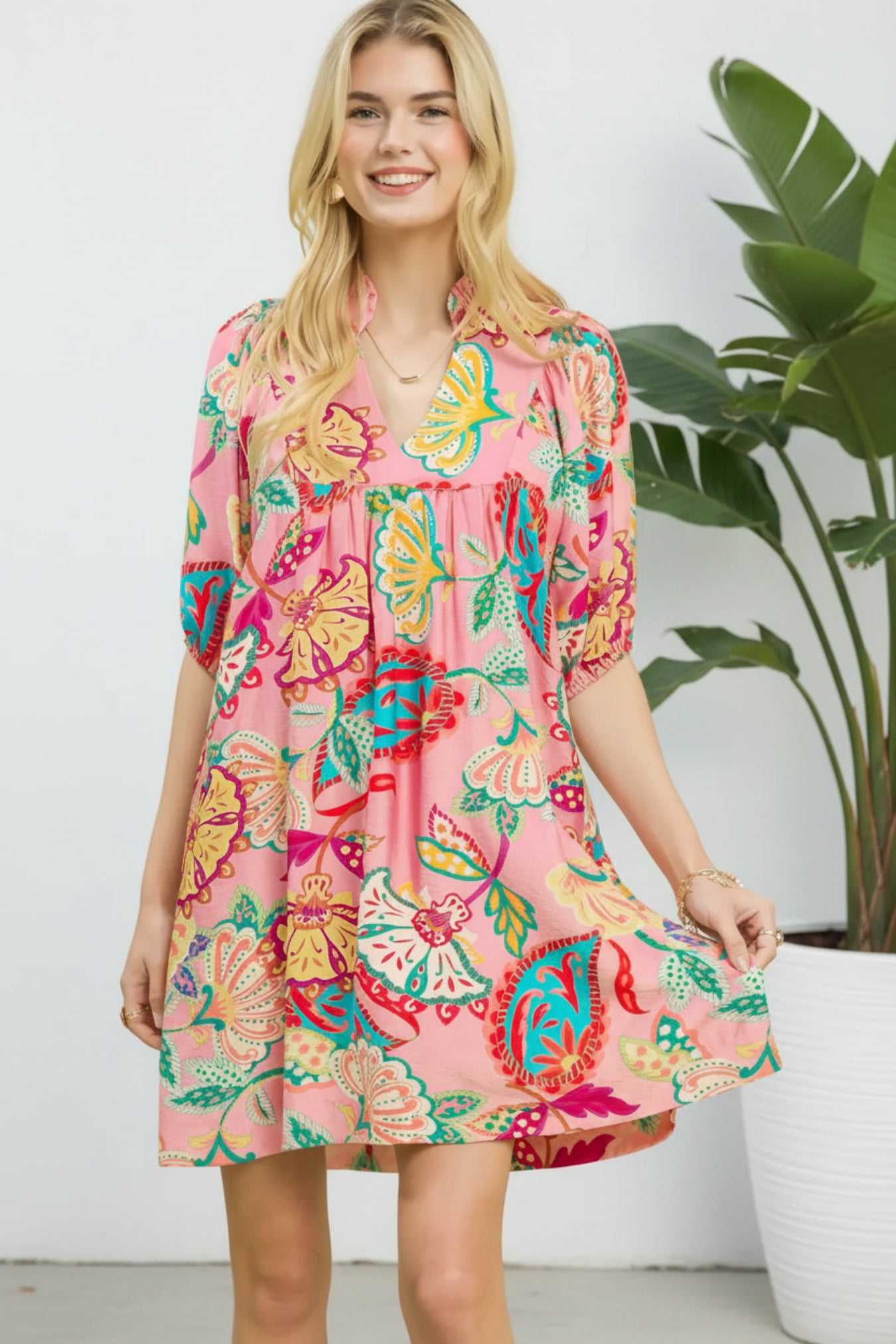 Woman wearing a colorful floral dress on a white background