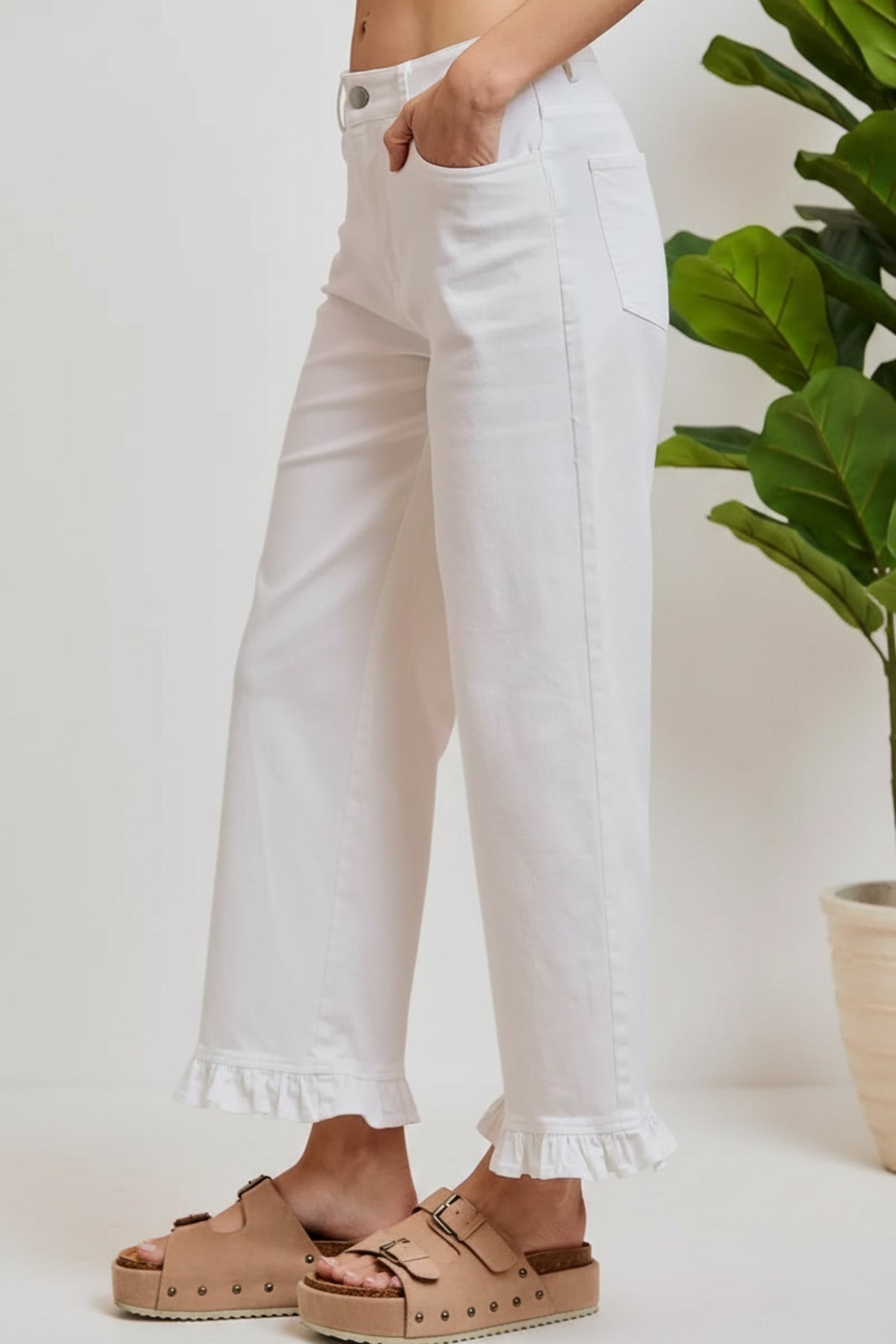 White pants with ruffled hem worn by a person on a white background