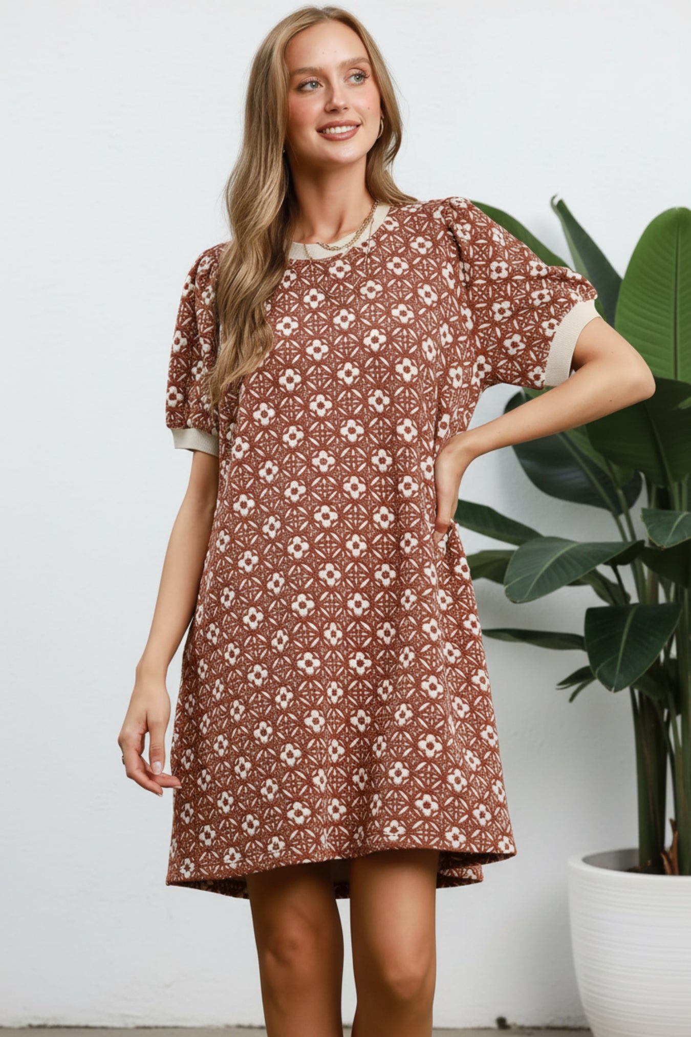Woman wearing a patterned dress on a solid background
