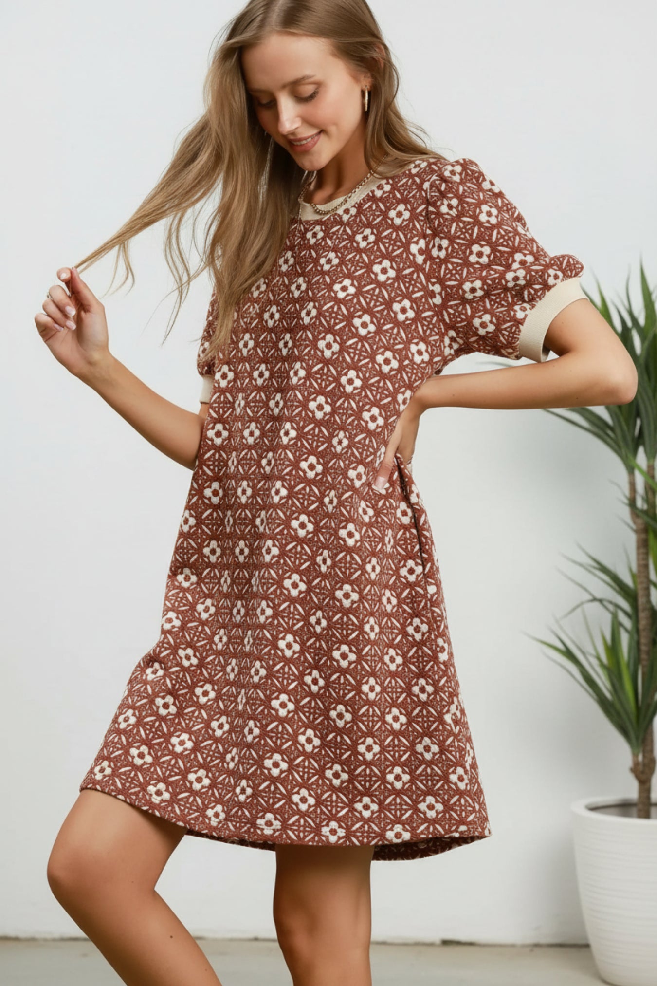 Woman wearing a patterned dress on a white background