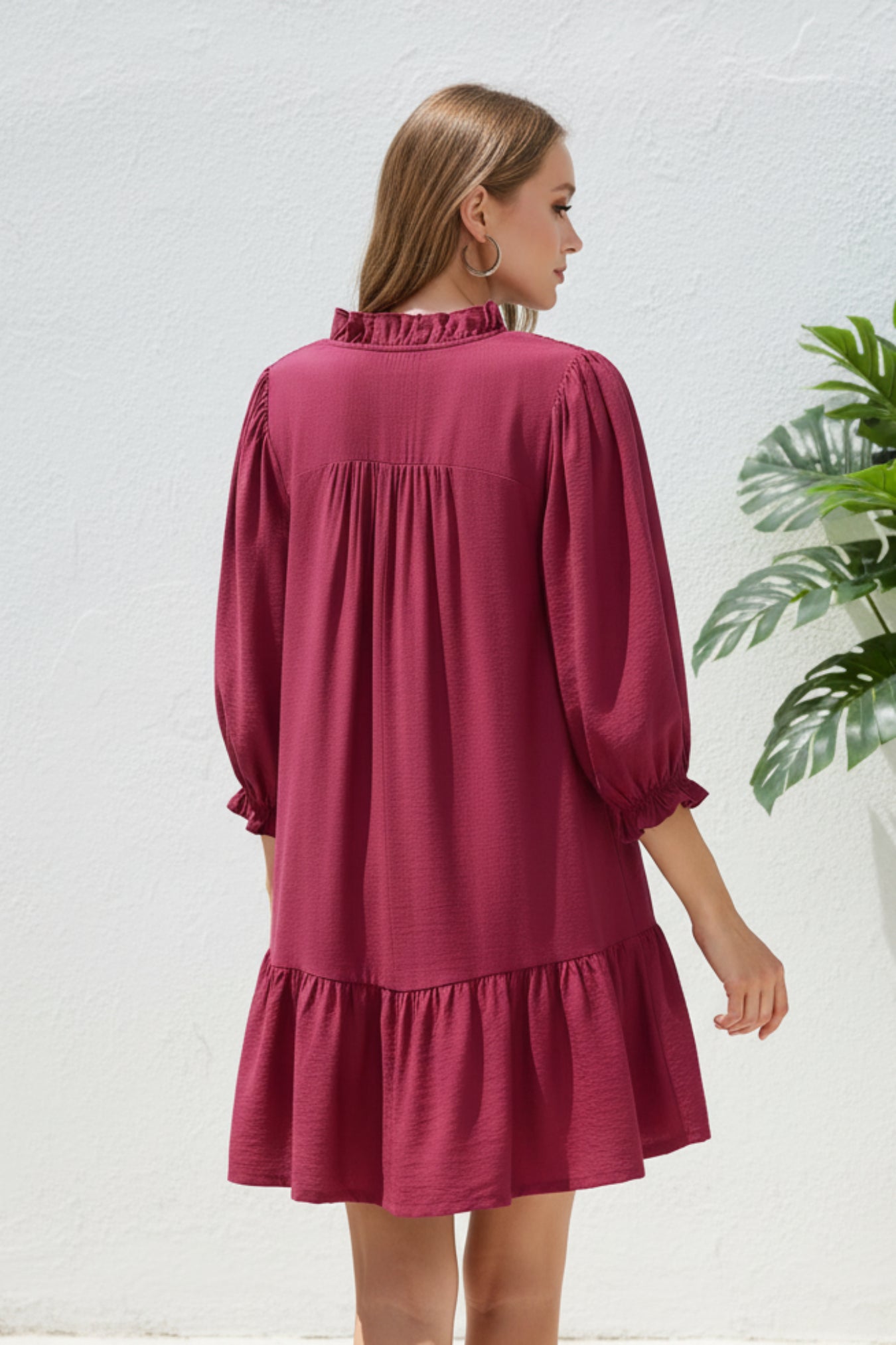 Woman wearing a mulberry dress on a white background