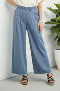 Light blue denim wide-leg pants worn by a person on a white background
