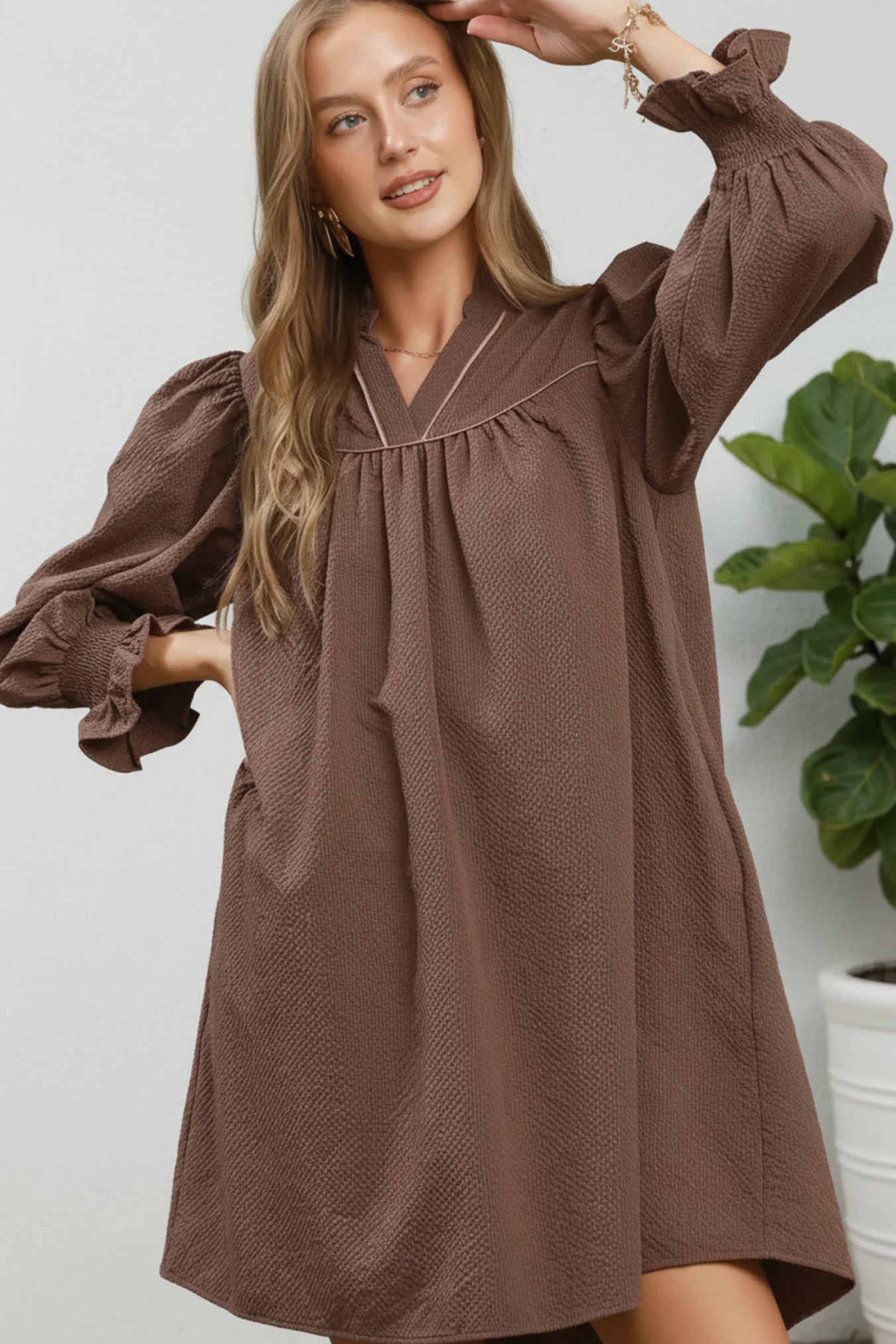 Woman wearing a brown dress against a green background