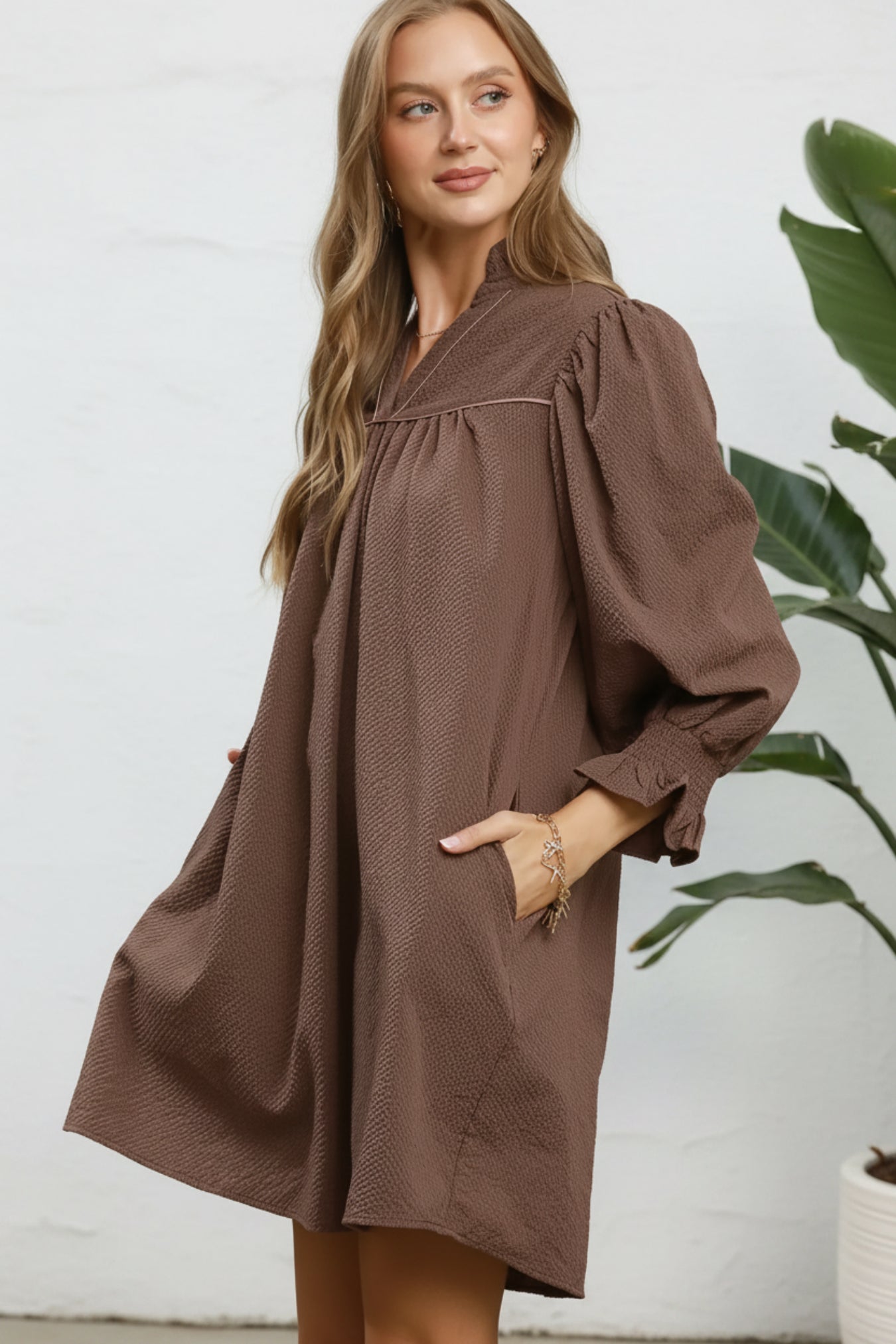 Woman wearing a brown dress against a white background