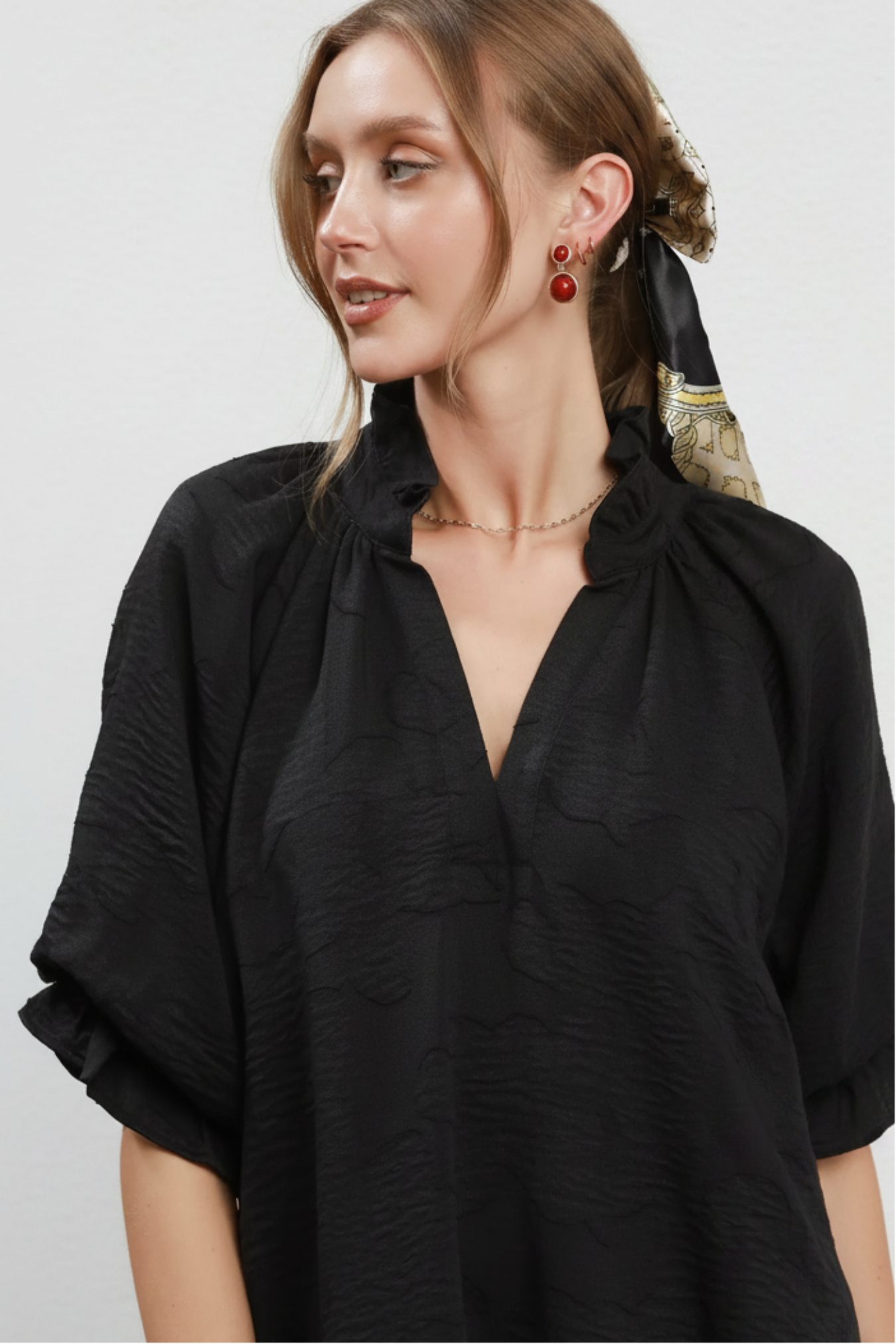 Woman wearing a black blouse with a white background
