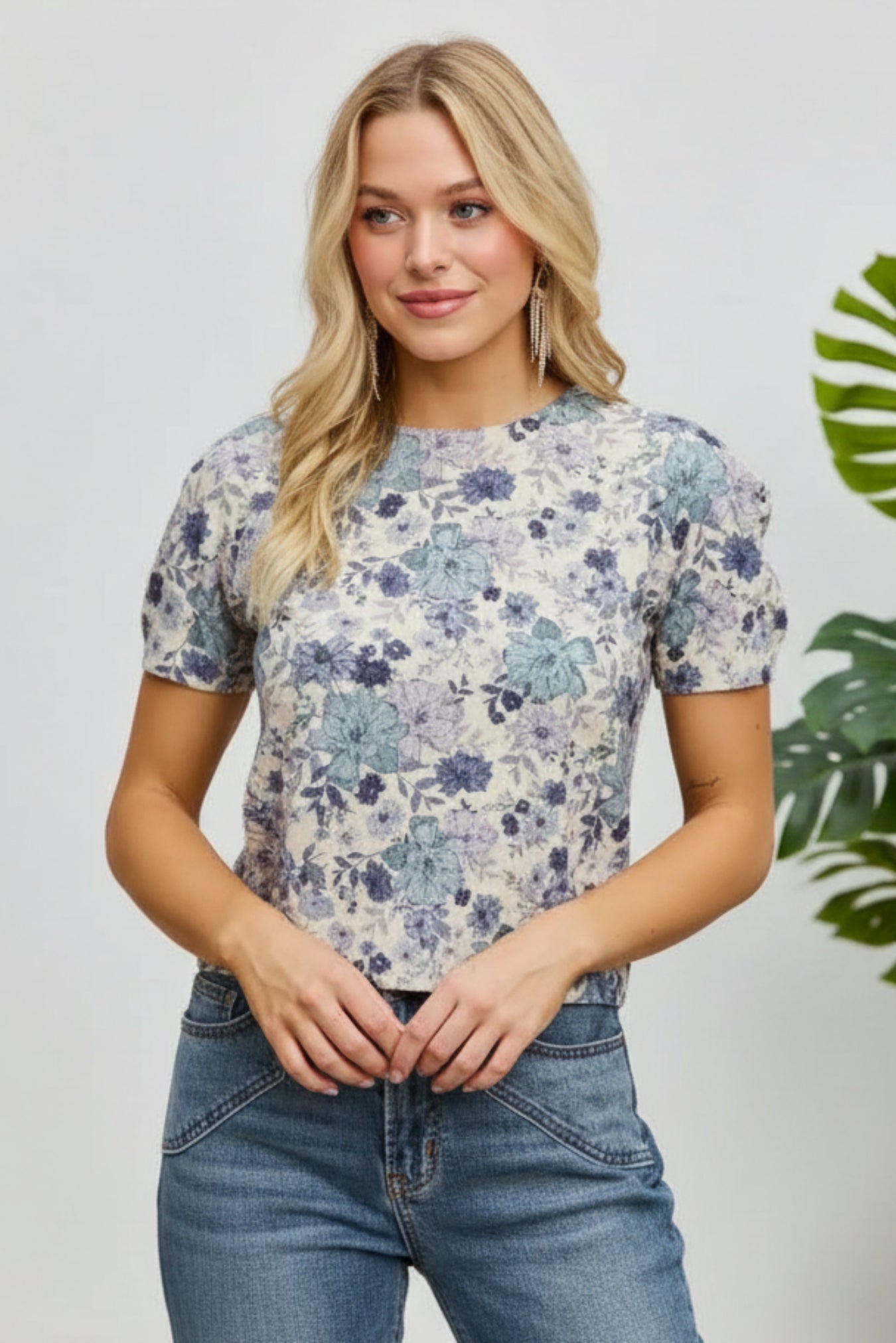 Woman wearing a floral patterned shirt against a white background