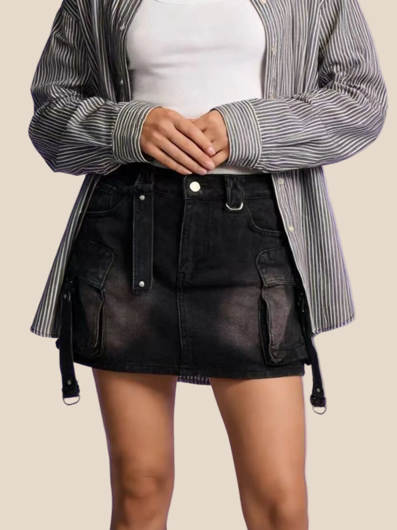 Person wearing a black leather skirt with a striped shirt on a purple background