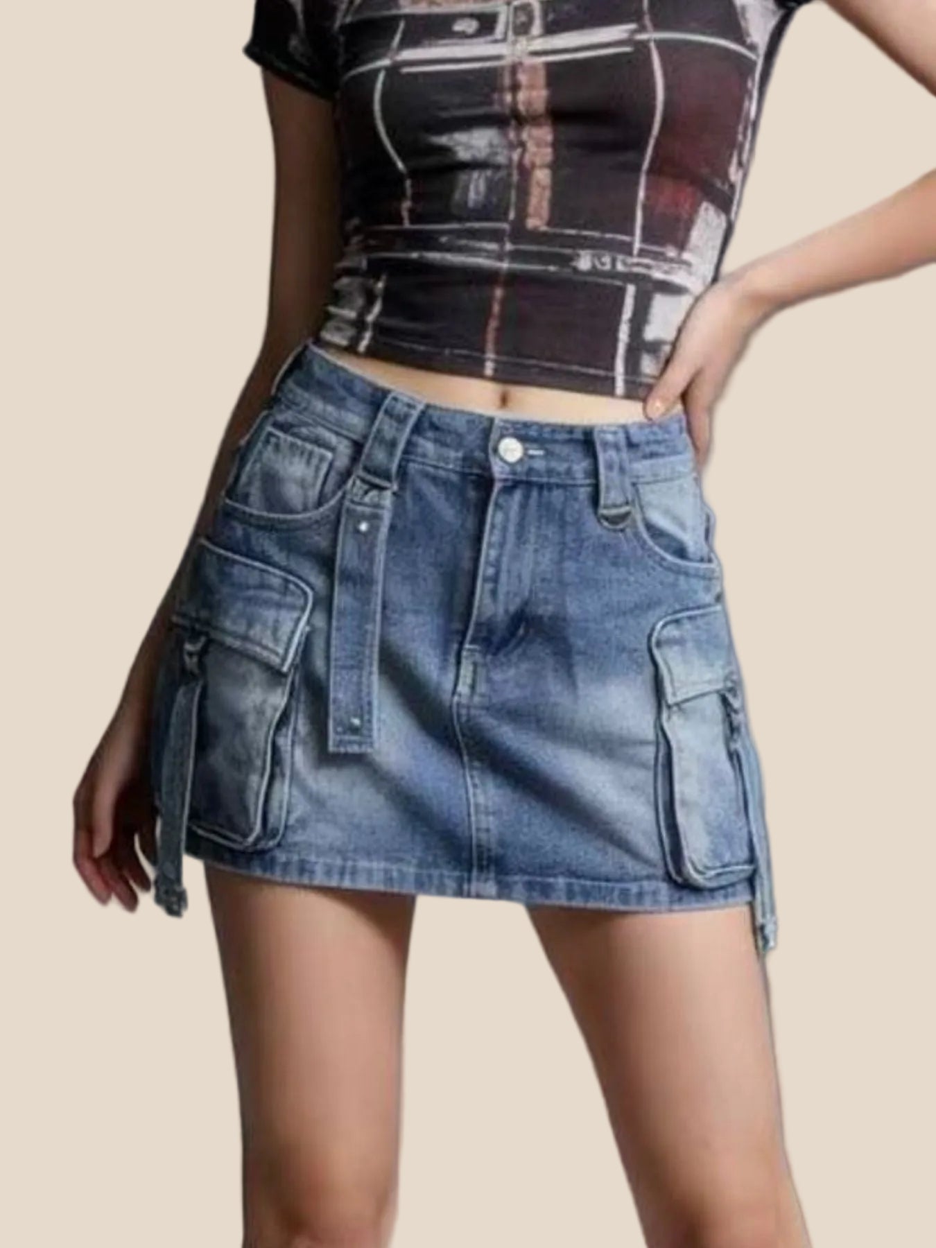 Person wearing a blue denim skirt and a patterned top on a gray background