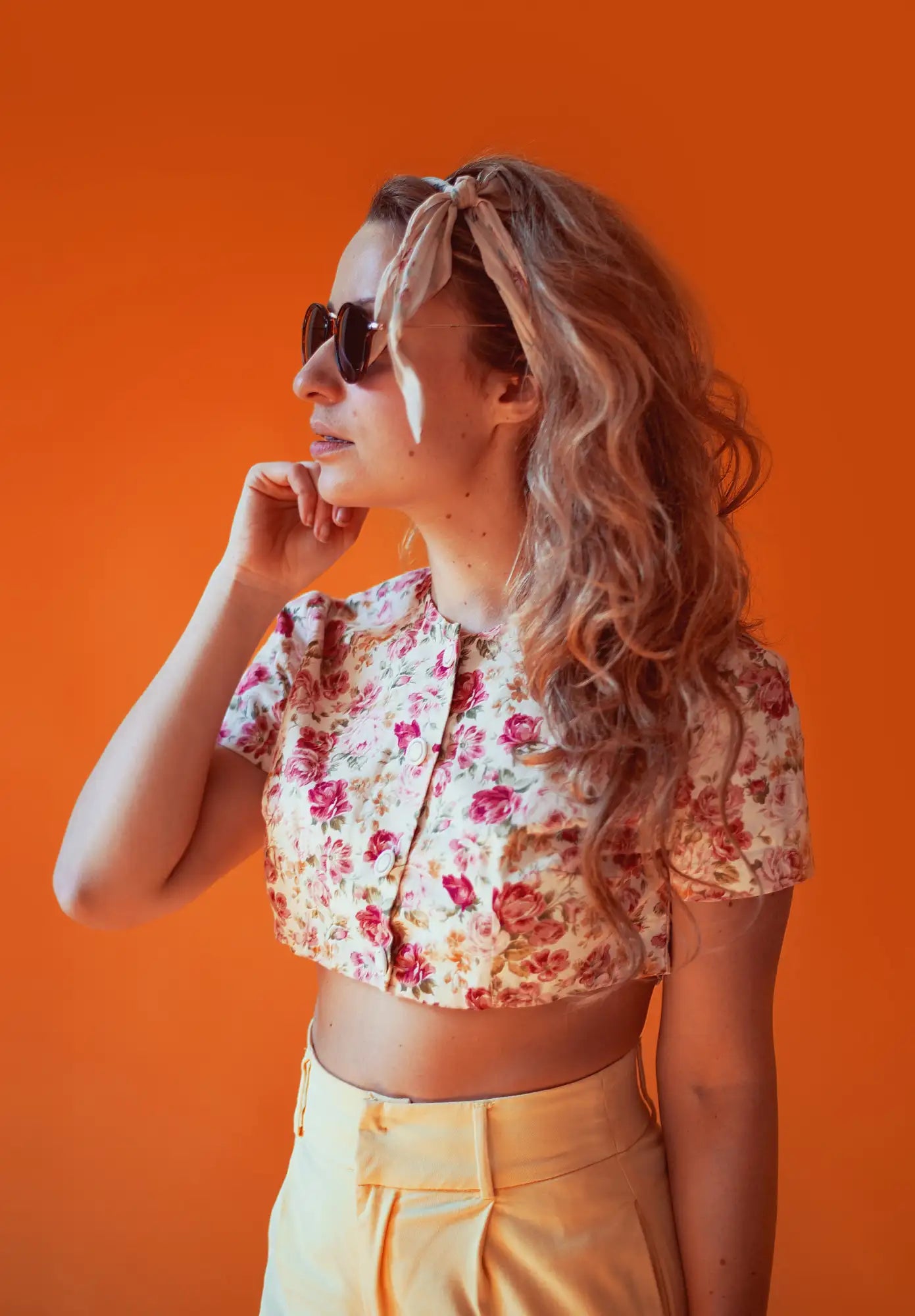 Floral print crop top with ruffled sleeves and yellow high-waisted pants.